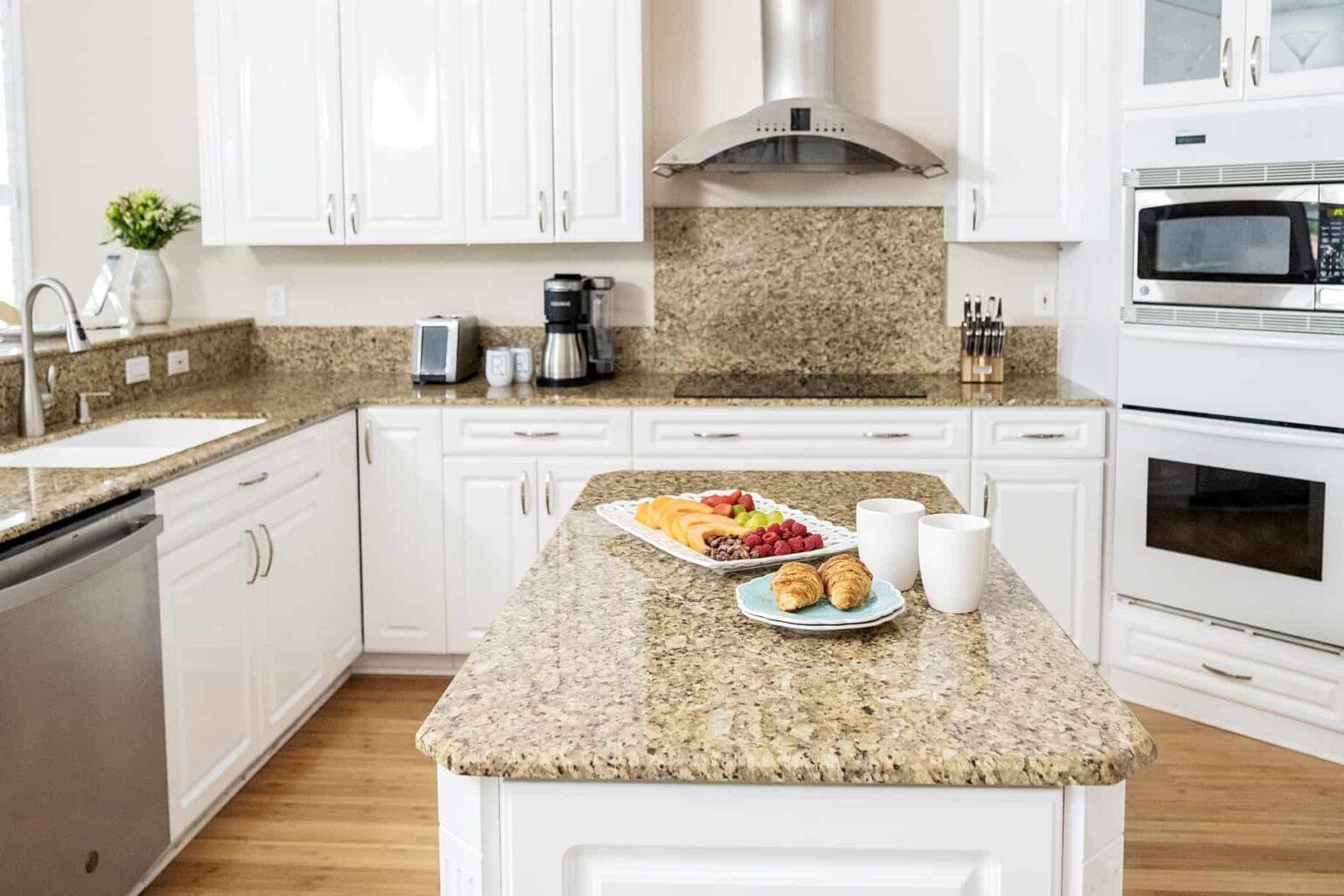 naples fl vacation home Kitchen island with built-in wine fridge / granite countertops throughout.