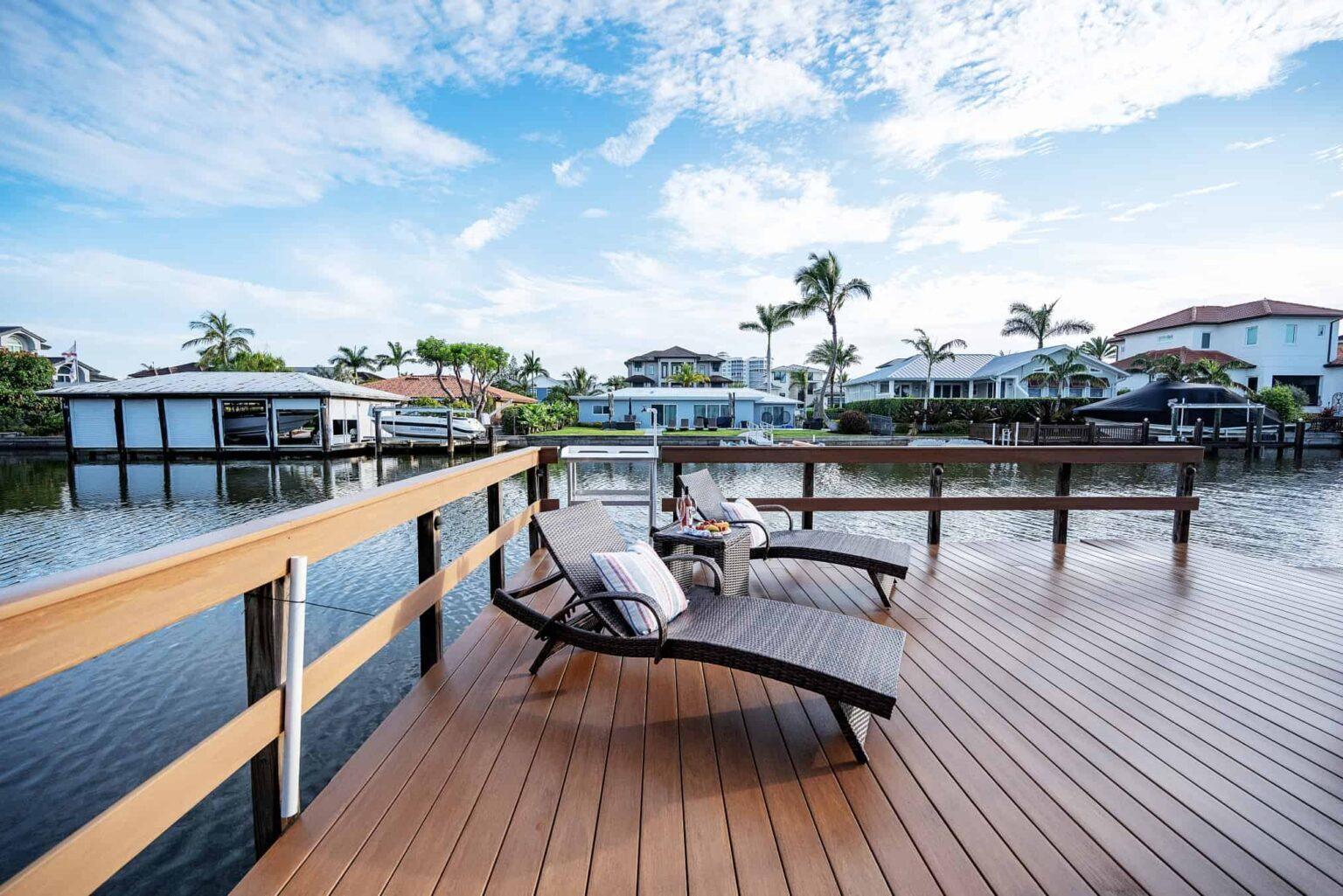 naples fl vacation home Private Boat Dock with lounge chairs and fish-cleaning station in background. with backyard patio overlooking canal